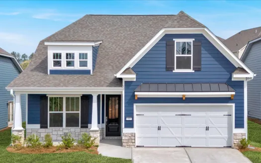 Modern blue house with white trim, stone foundation, front porch, and attached two-car garage under clear sky