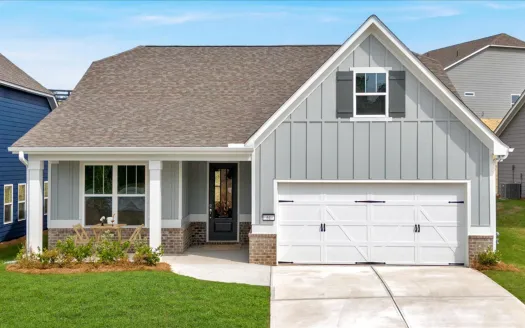 Modern gray house with white garage door, porch with seating, and manicured lawn under clear sky