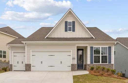 Modern beige house with a double garage, dark blue shutters, and a clear sky background